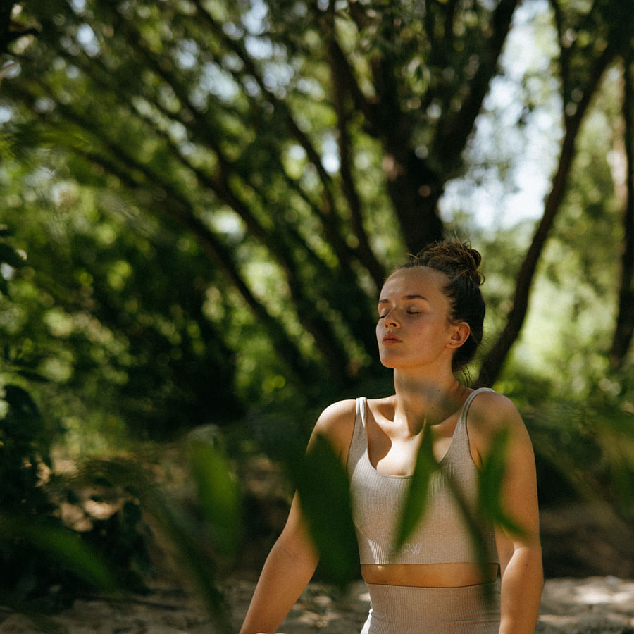Person peacefully meditating on a wooden bench in a serene environment